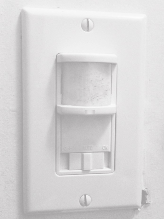 White lightswitch plate with a sensor in the middle.