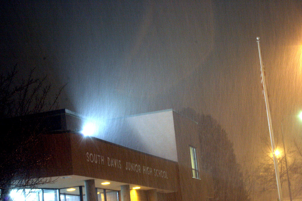 Photo taken outside next to a building emitting light. The air is cloudy and the sky looks lit by the buildings instead of pitch black.