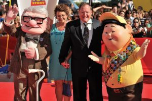 John Lasseter on the red carpet with life size figures of main characters Carl and Russell. 