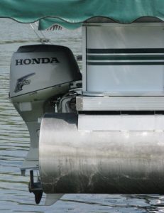 Side view of a Honda motor attached to a pontoon boat in the water. 