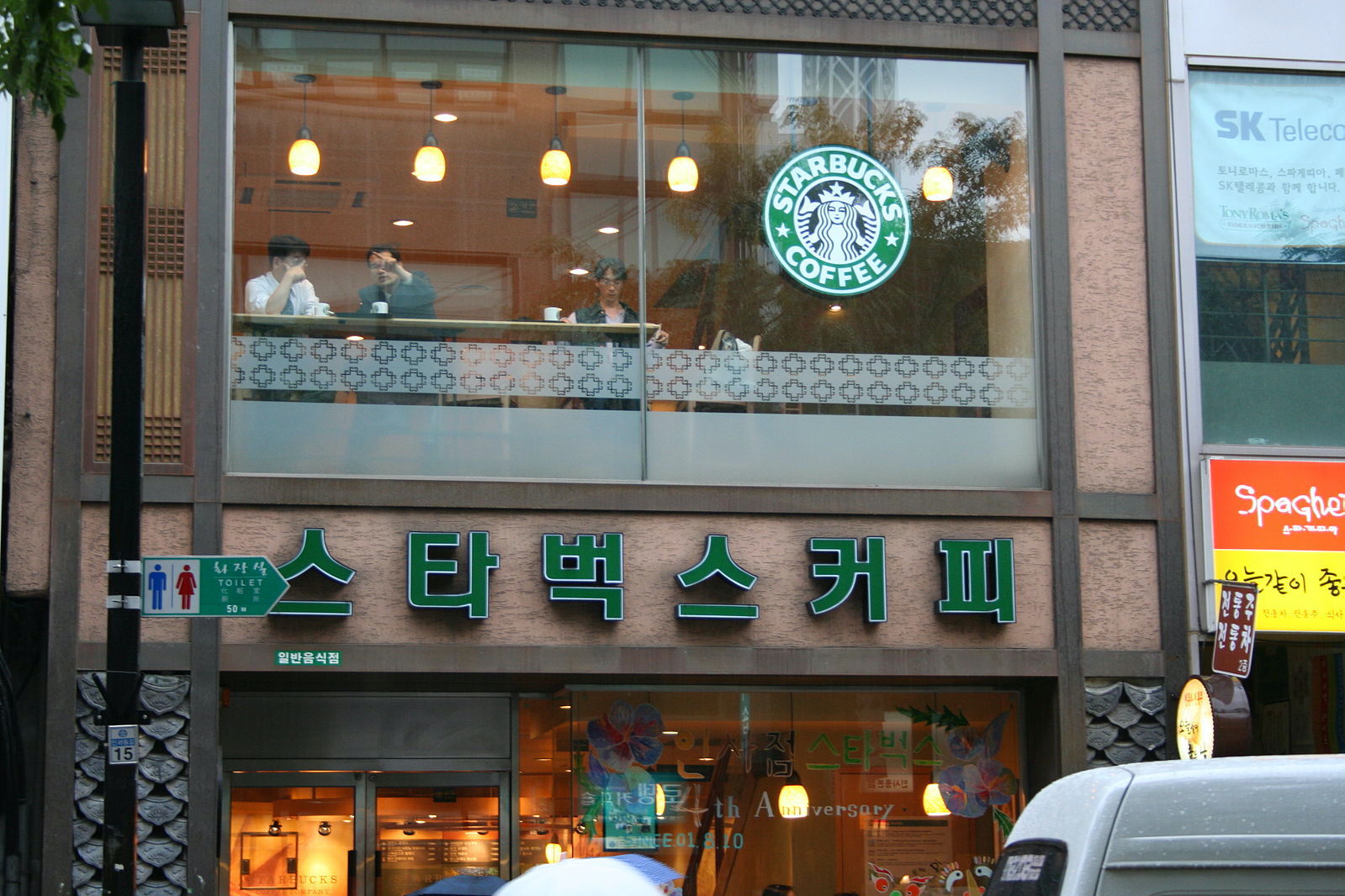 Street view of a Starbucks in Seoul, South Korea. There are green Korean characters on the building.