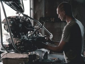 Man inspecting an engine in an auto shop.