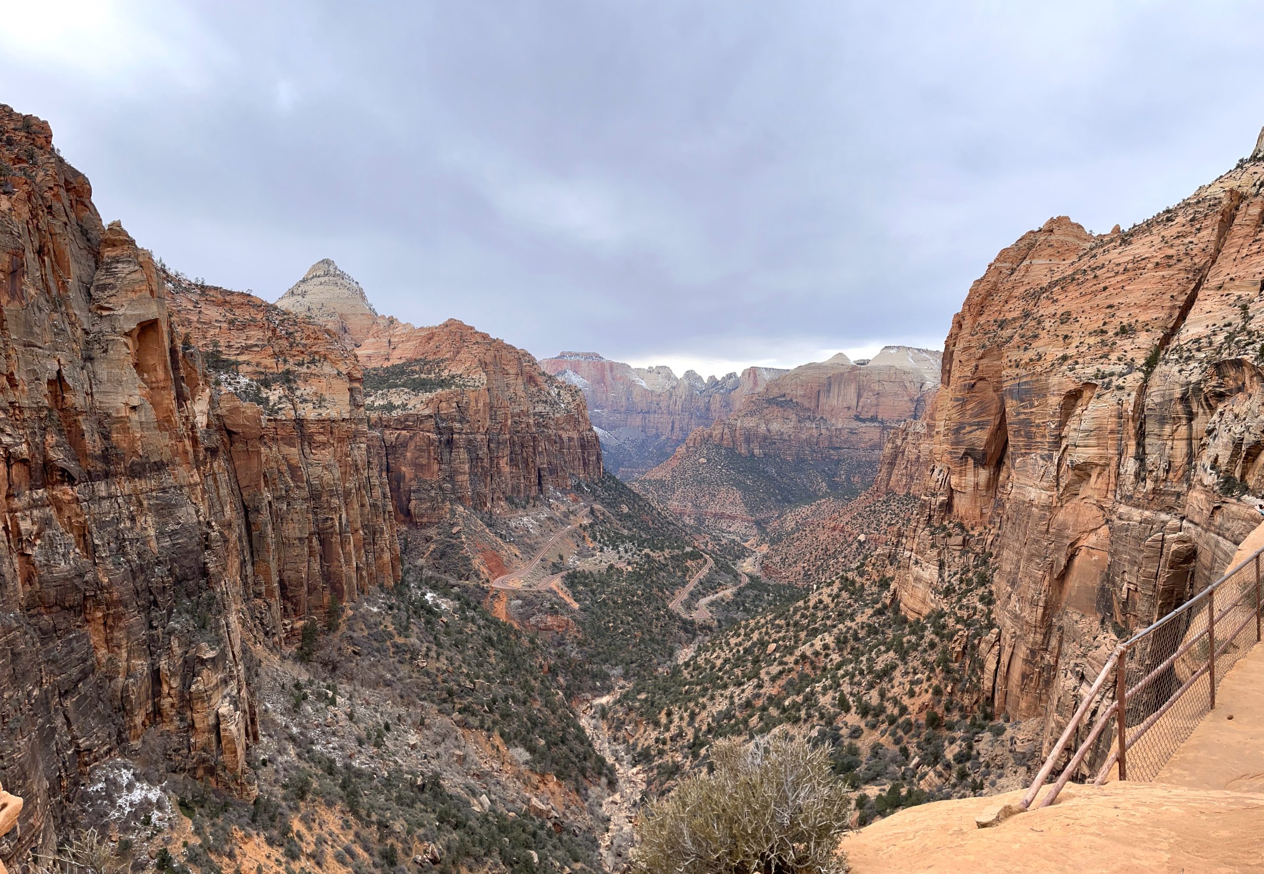 Steep canyon with cliffs of horizontal tan and brown rock layers that match up on either side of the canyon.