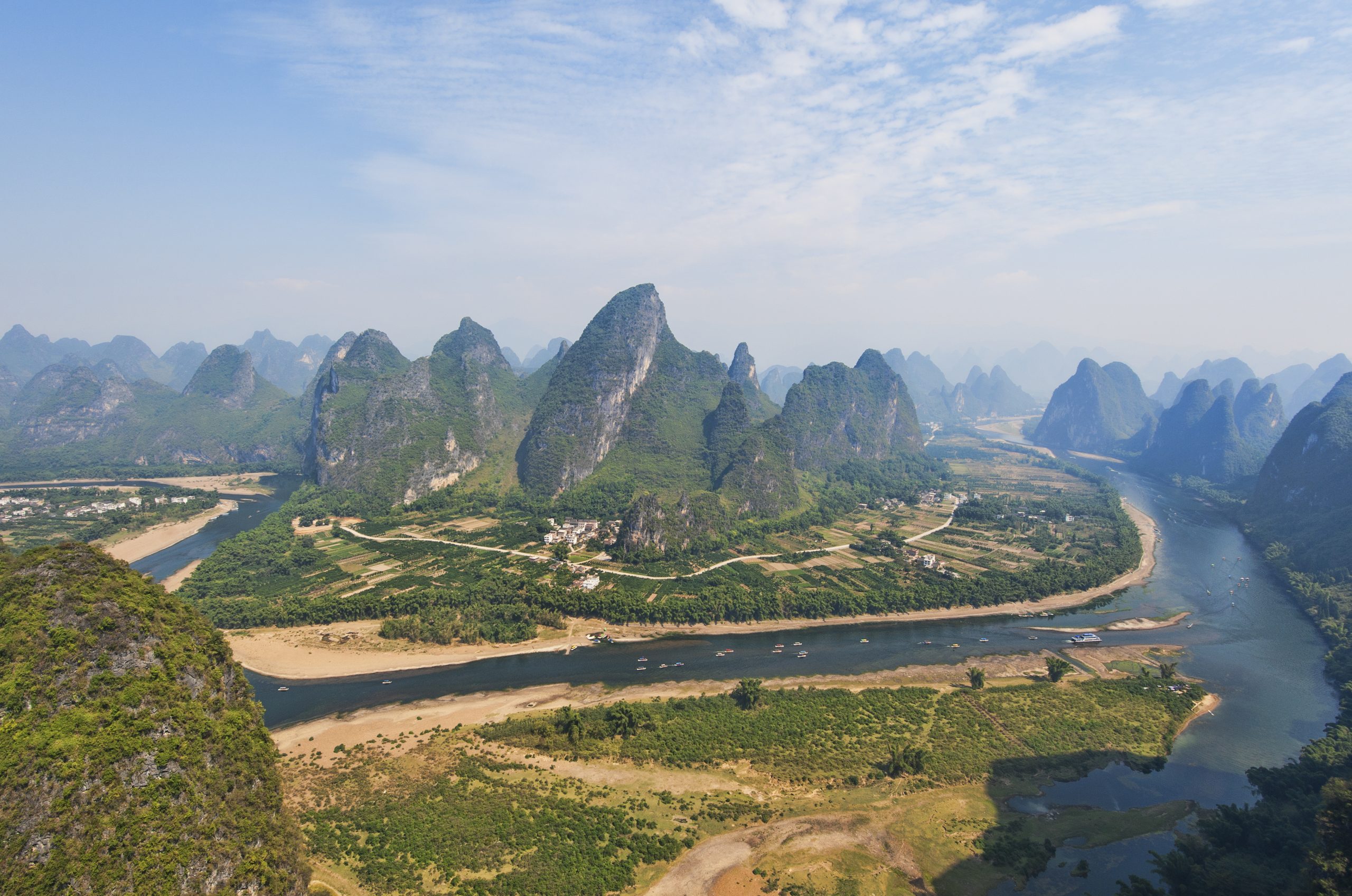 River flowing across landscape of flat land with steep rock towers rising from the land.