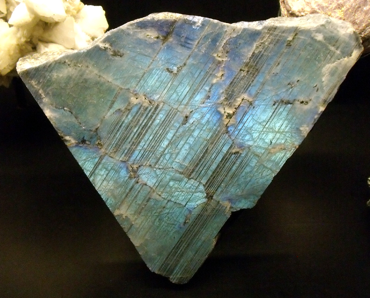 Striations or parallel dark lines on one cleavage surface on plagioclase feldspar that has an iridescent blue-green sheen.