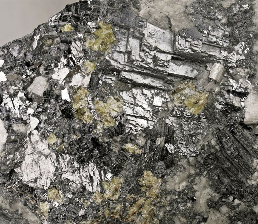 Dark gray metallic sample of galena; cubic cleavage is visible in various layers of the sample.