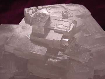 Whitish glassy sample of halite with cubic crystals visible.