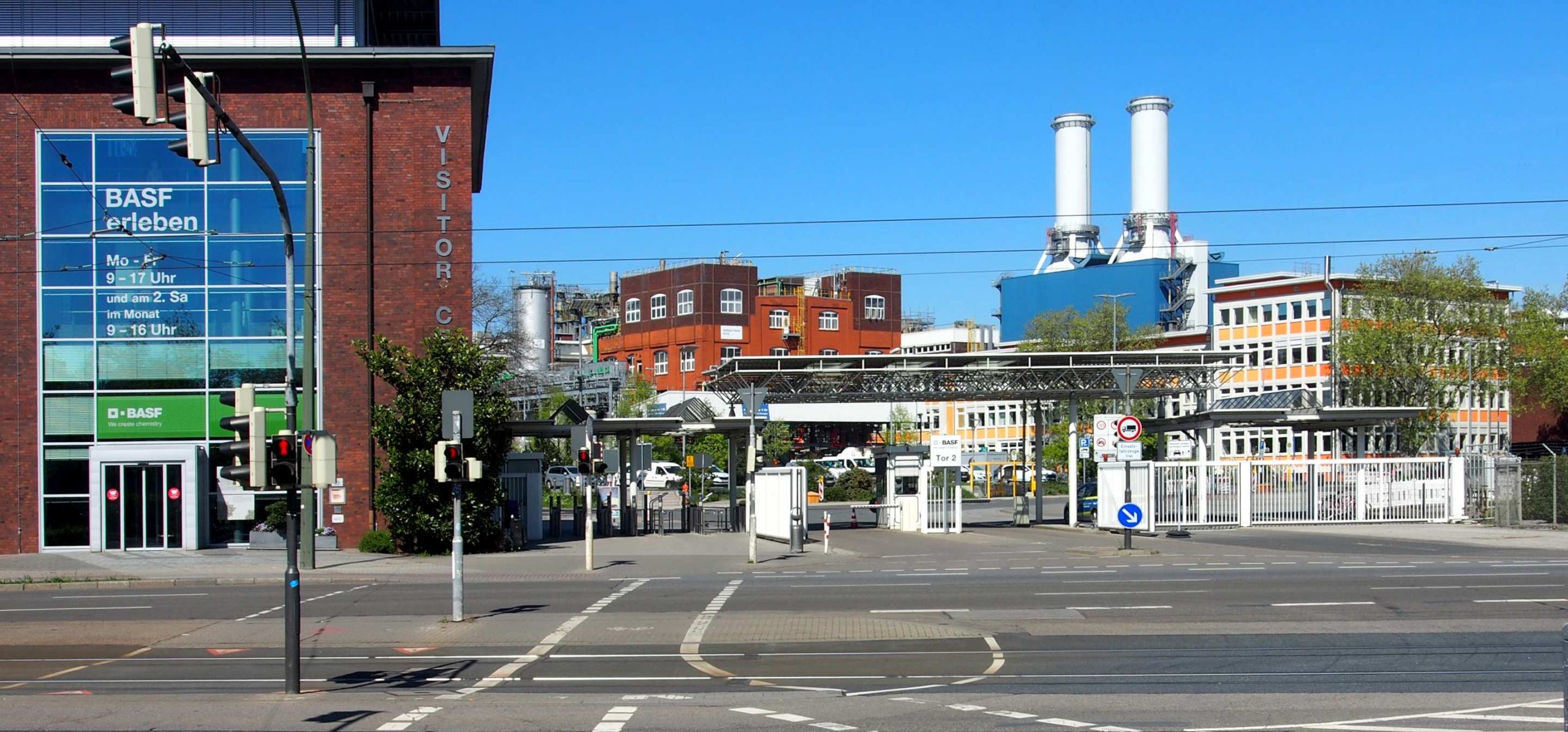 Urban industrial scene under a clear blue sky. A brick building is on the left with BASF signage