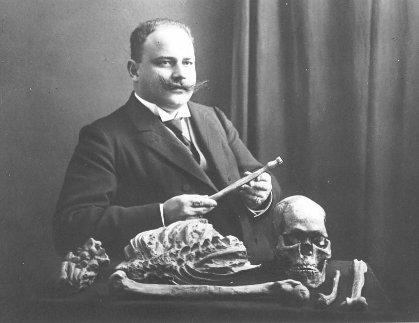 Otto Hauser sitting next to the human skeleton Combe-Capelle