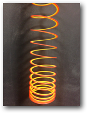 A coiled slinky with the top coils stretched apart farther than the bottom coils which are stacked close together