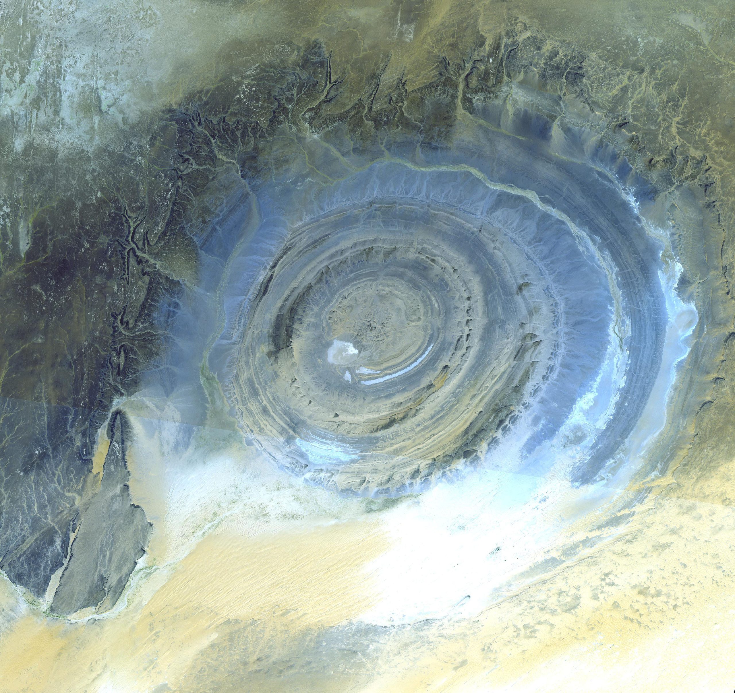 View of a dome from space. The upwarped beds of rock form concentric circles, where the center of the dome has been eroded away.