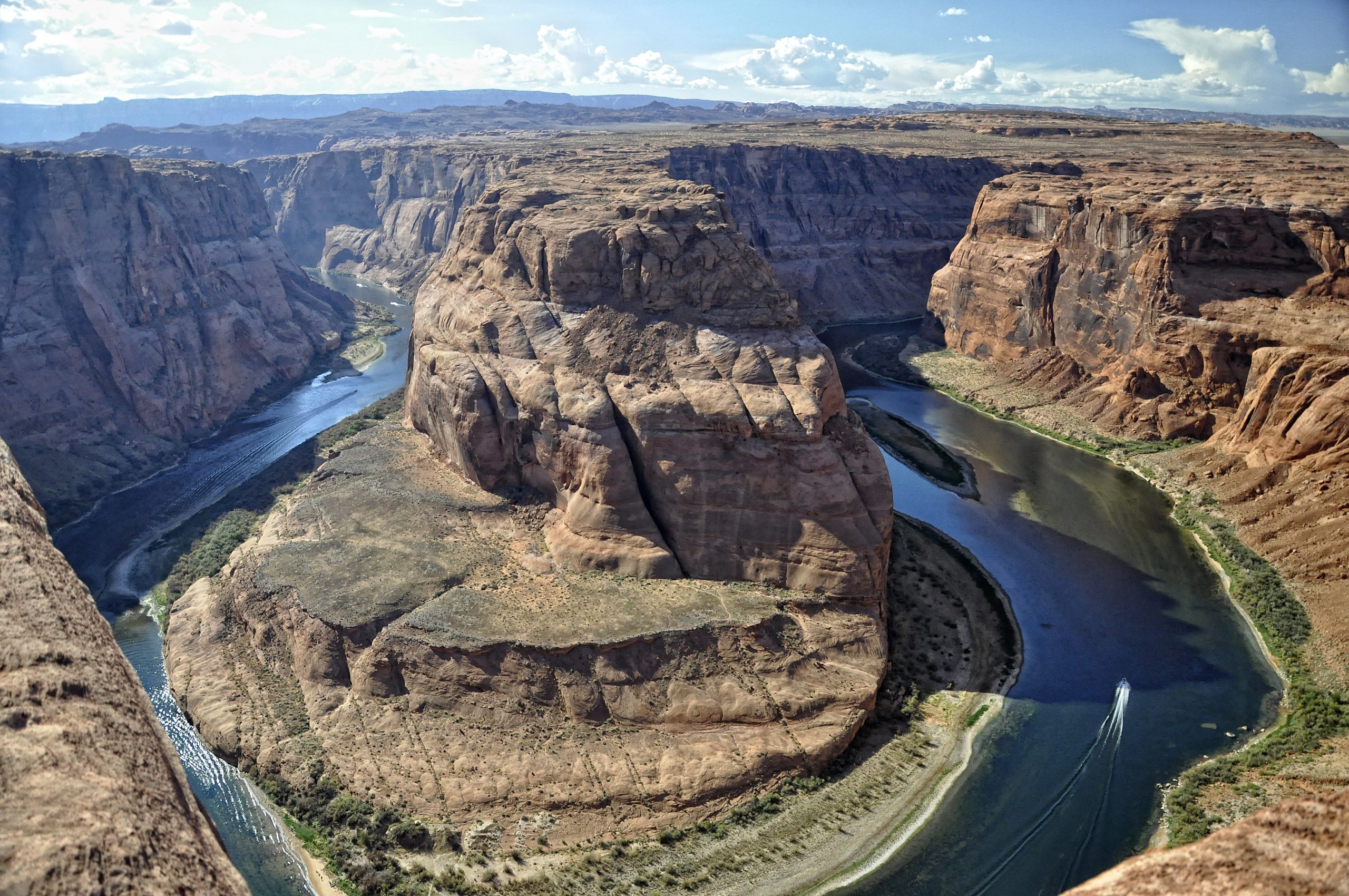 Steep U-shaped canyon; a river with narrow shores fills in the gorge.