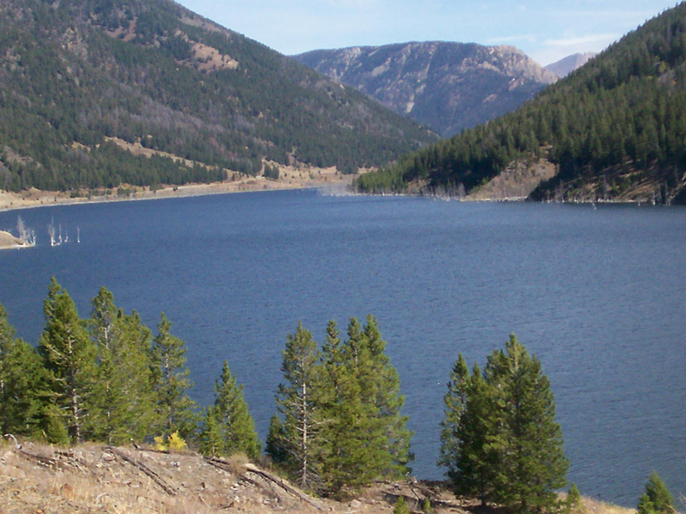 A lake surrounded by forest-covered mountain slopes.