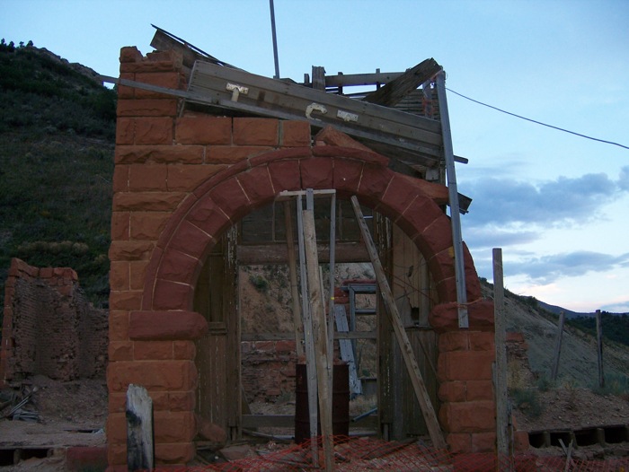 Extremely damaged brick structure with only an archway remaining.