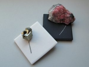 Pyrite showing a black streak on a white streak plate and rhodochrosite with a white streak on a black streak plate