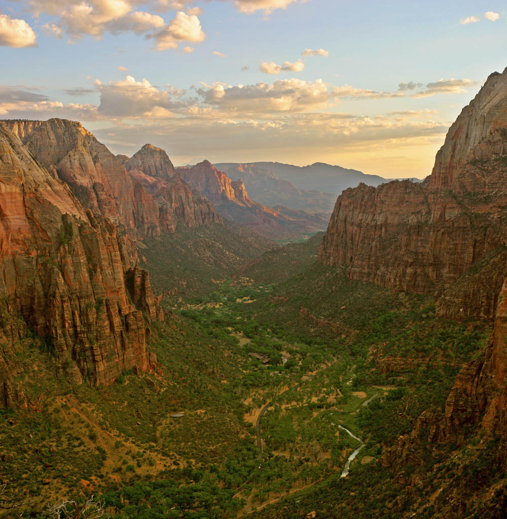 Steep canyon with cliffs of horizontal tan and brown rock layers that match up on either side of the canyon.