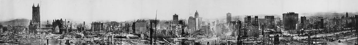 Wide view of rubble and skeletons of buildings that remain, some still smoking.