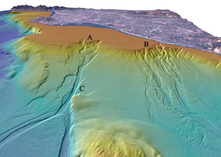 Perspective view looking north over two submarine canyons. The distance across the bottom of the image is about 17 km with a vertical exaggeration of 6x. Newport Canyon is labeled B and is composed of individual channels that braid down the slope over a width of about 9 km. The San Gabriel Canyon is labeled A and begins as a series of channels that join together midway down the slope and then split into two channels at the base of the slope. The width of San Gabriel Canyon about halfway down the slope, labeled C, is 815 m and incises about 25 m into the slope.