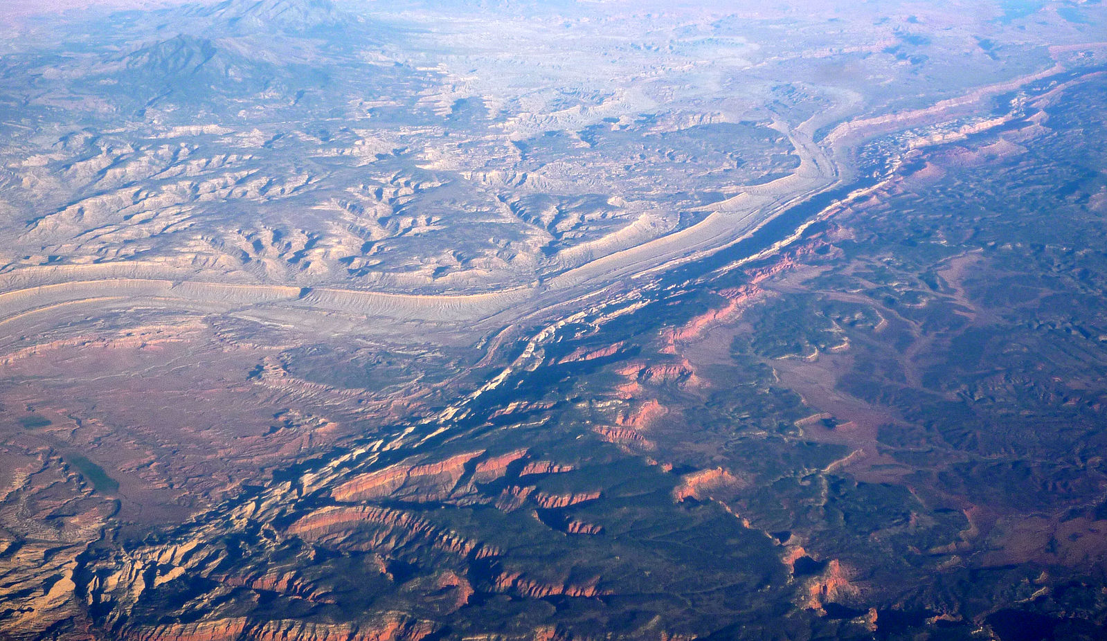 Aerial view of a long, thin whitish ridge that runs through the surrounding tan to brown landscape.