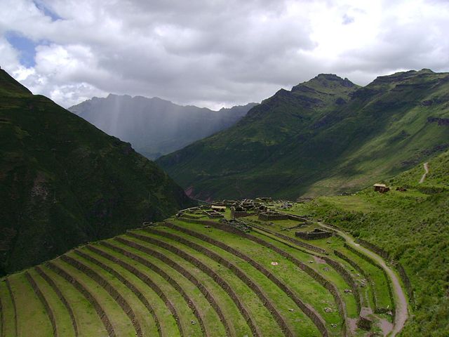 A mountain slope has been made into artificial steps for farming, covered in low green vegetation.