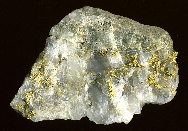 Chunk of glassy white mineral with thin gold veins running through the sample.