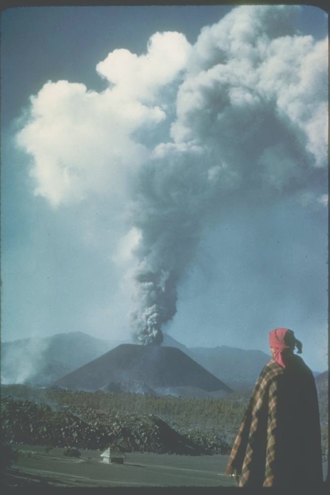 A person looks at the eruption of ash