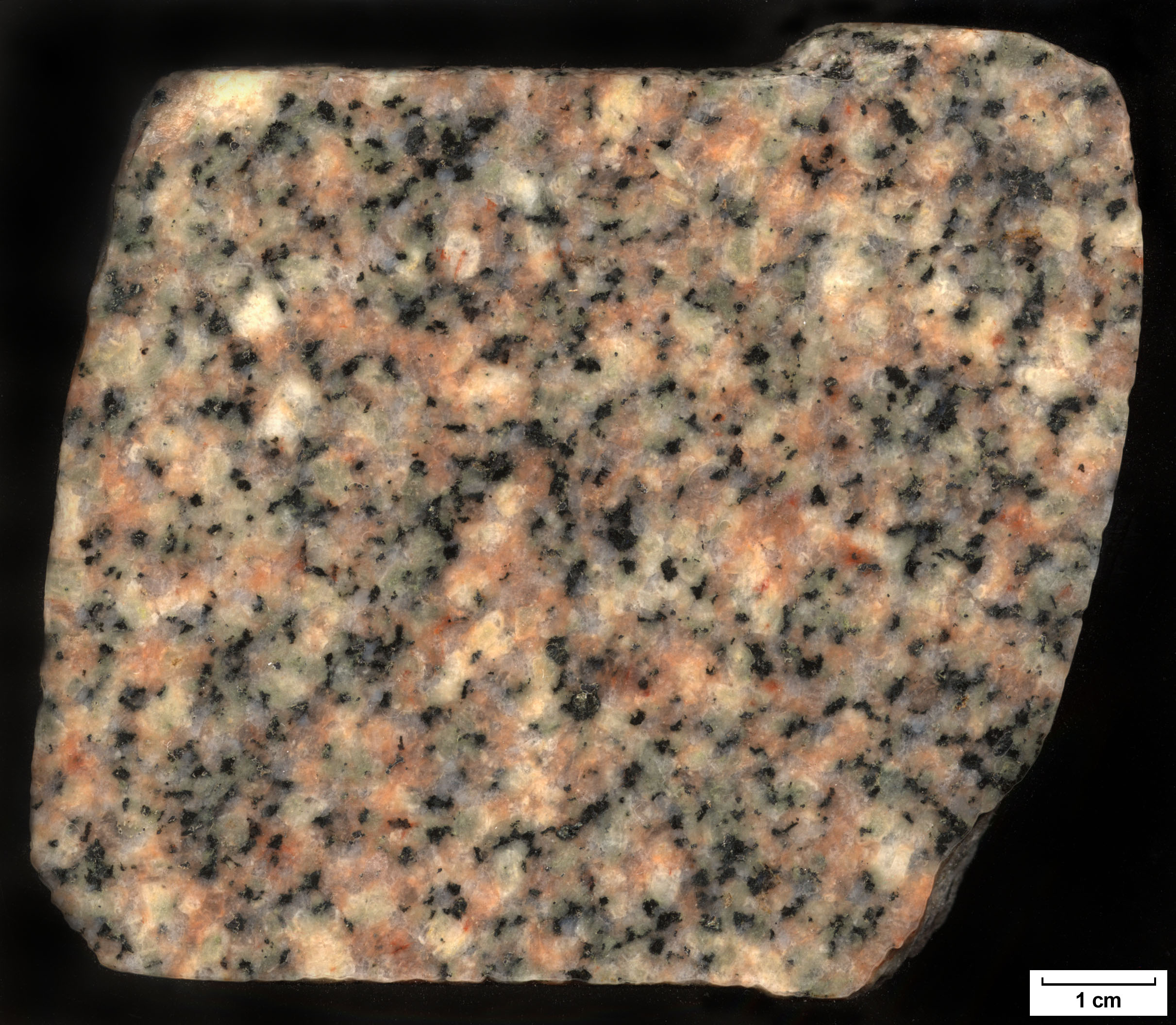 Solid, opaque, square shaped, smooth sided rock with specs of pink, black, gray, and cream particles