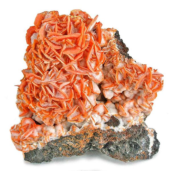 Orange stringy mineral on white block