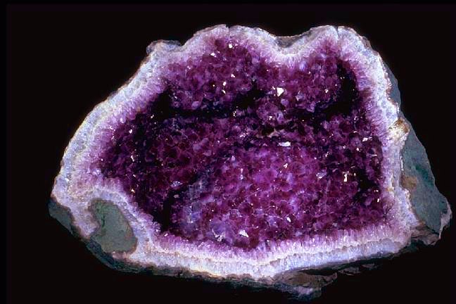 The rock is hollowed and filled with purple minerals