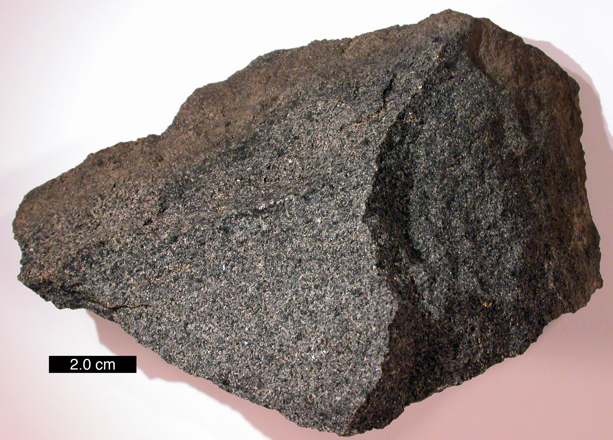 Solid, opaque, roughly triangular, fine-grained rock made of small brown and black particles