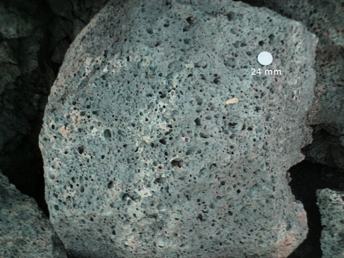 Solid, opaque, porous rock with smooth edges that is bluish gray